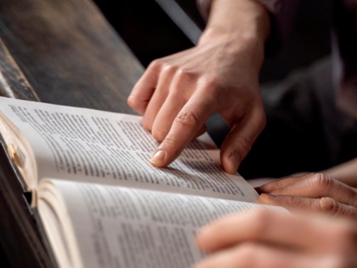 close-up-priest-reading-form-bible